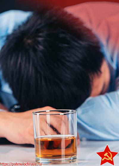 мужчина спит за столом рядом со стаканом с алкоголем